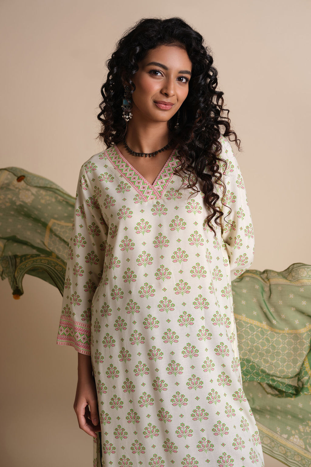Woman wearing a white floral patterned kurta with a beige background