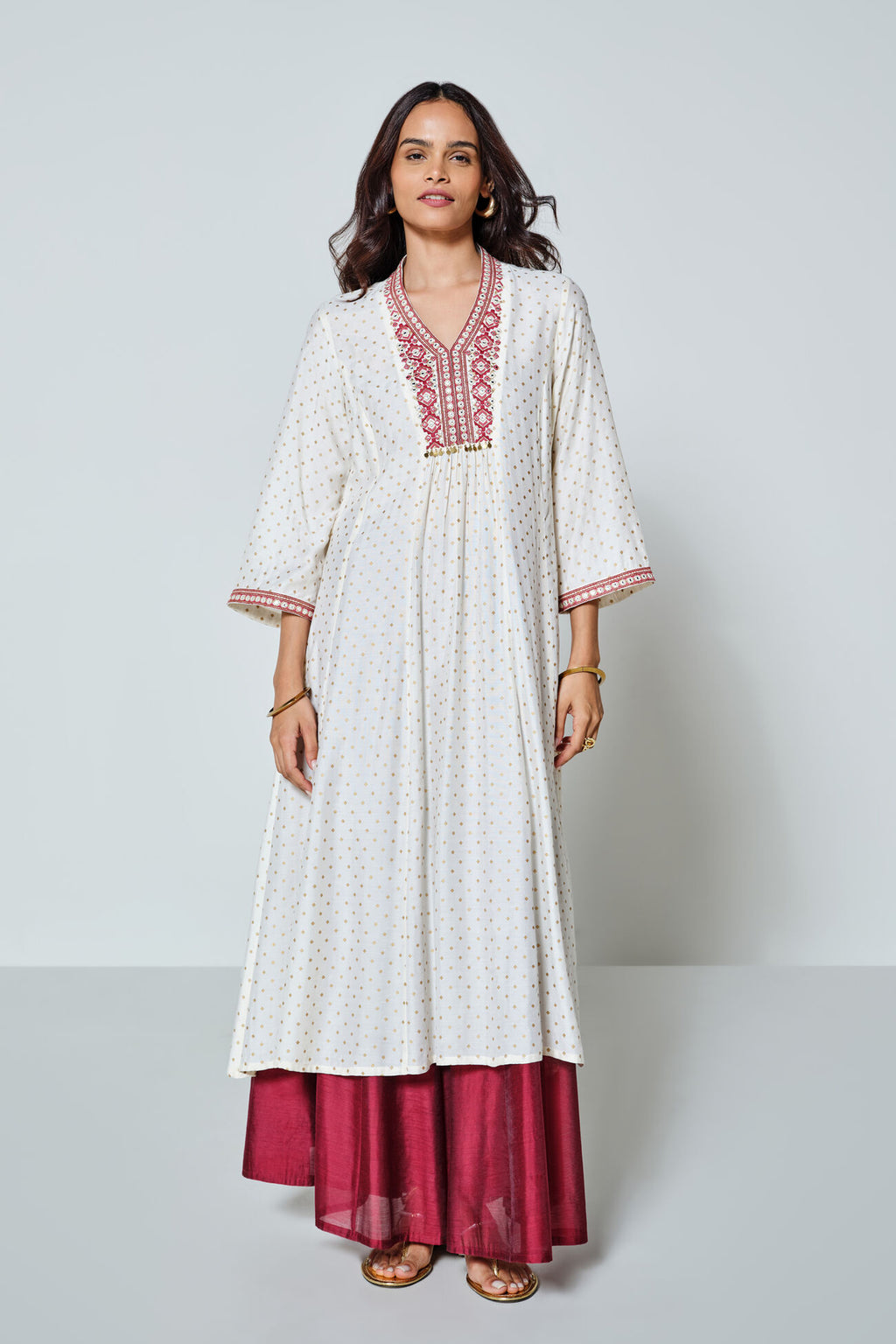 Woman wearing a white and red traditional outfit with a plain background