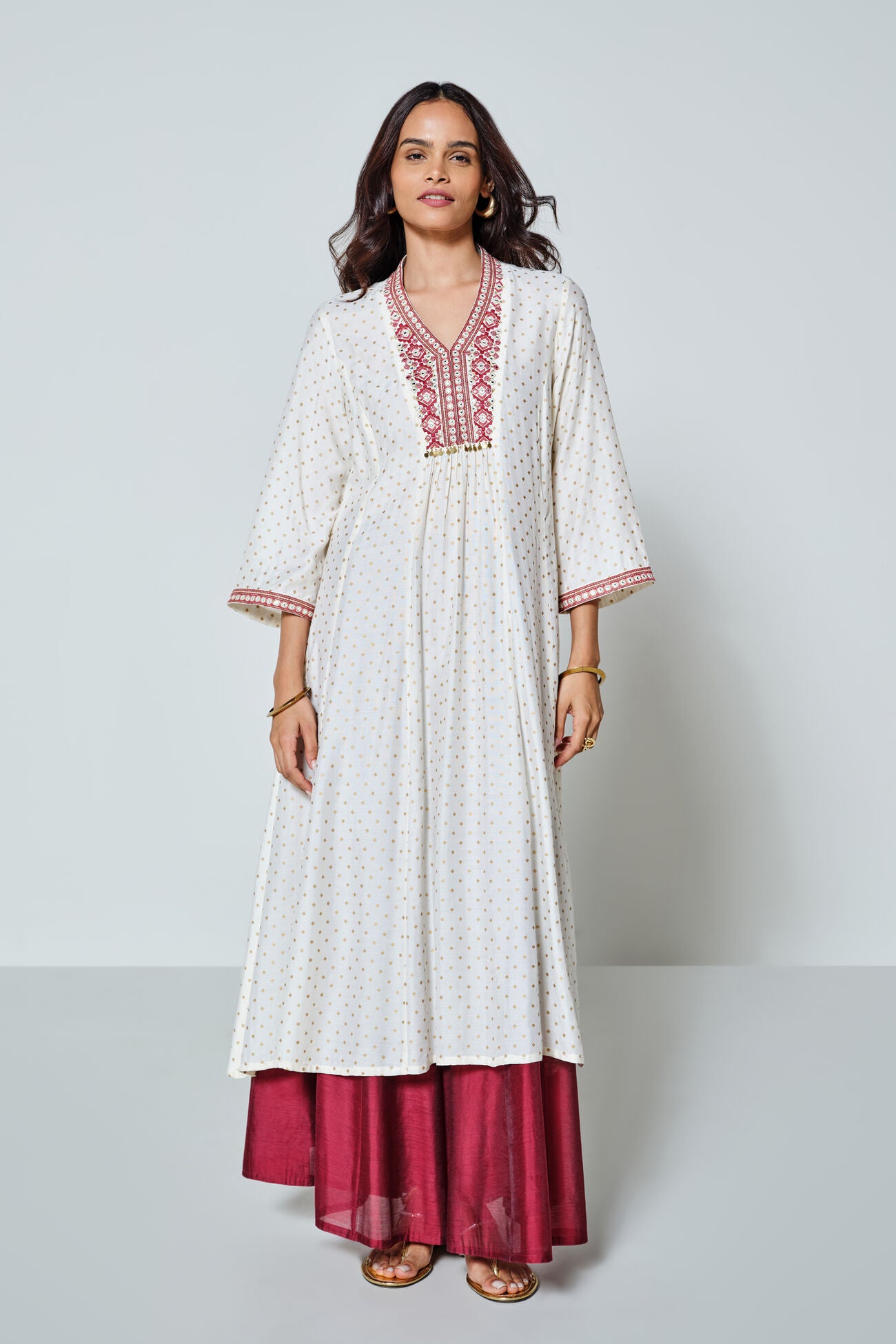 Woman wearing a white and red traditional outfit with a plain background