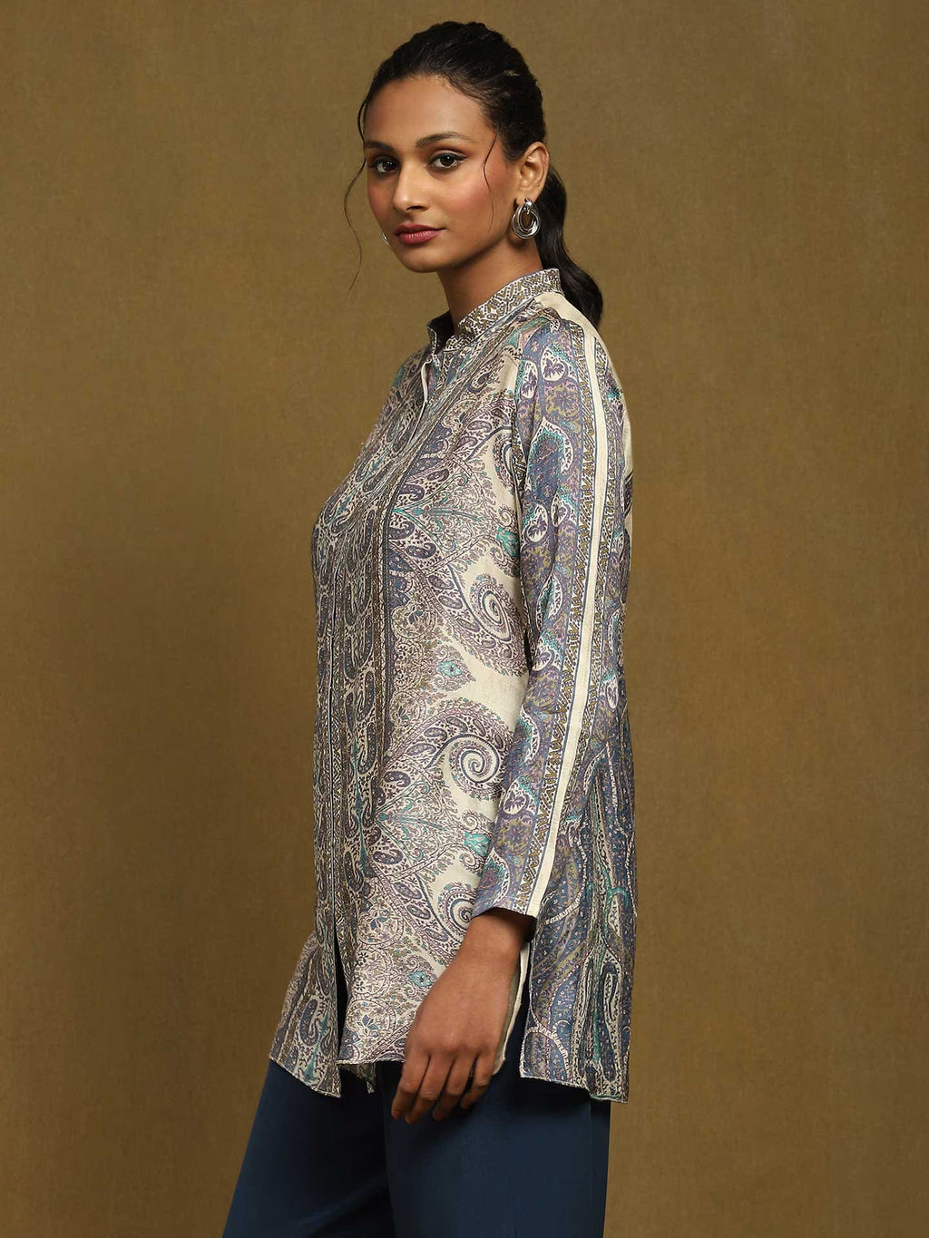 Woman wearing a patterned Kurta against a brown background