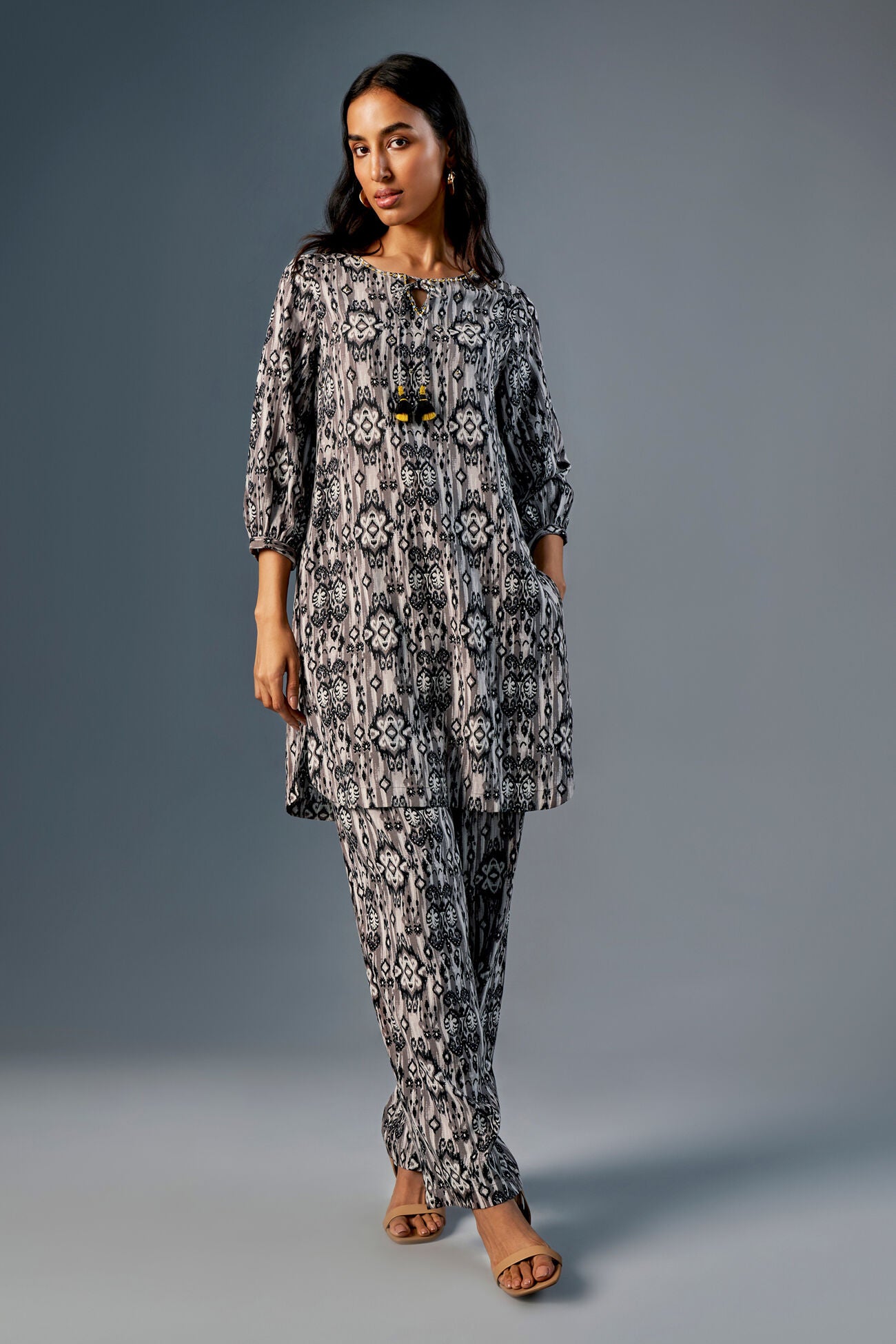 Woman wearing a patterned outfit on a gray background