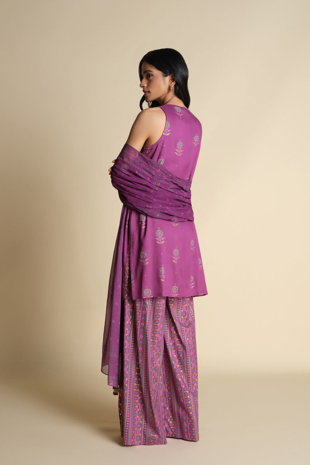 Woman wearing a purple traditional outfit with a plain background