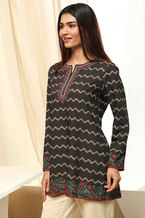 Woman wearing a black zigzag patterned kurta with floral embroidery against a white background