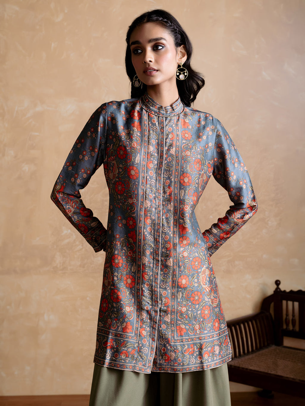 Woman wearing a patterned long-sleeve top with a neutral background