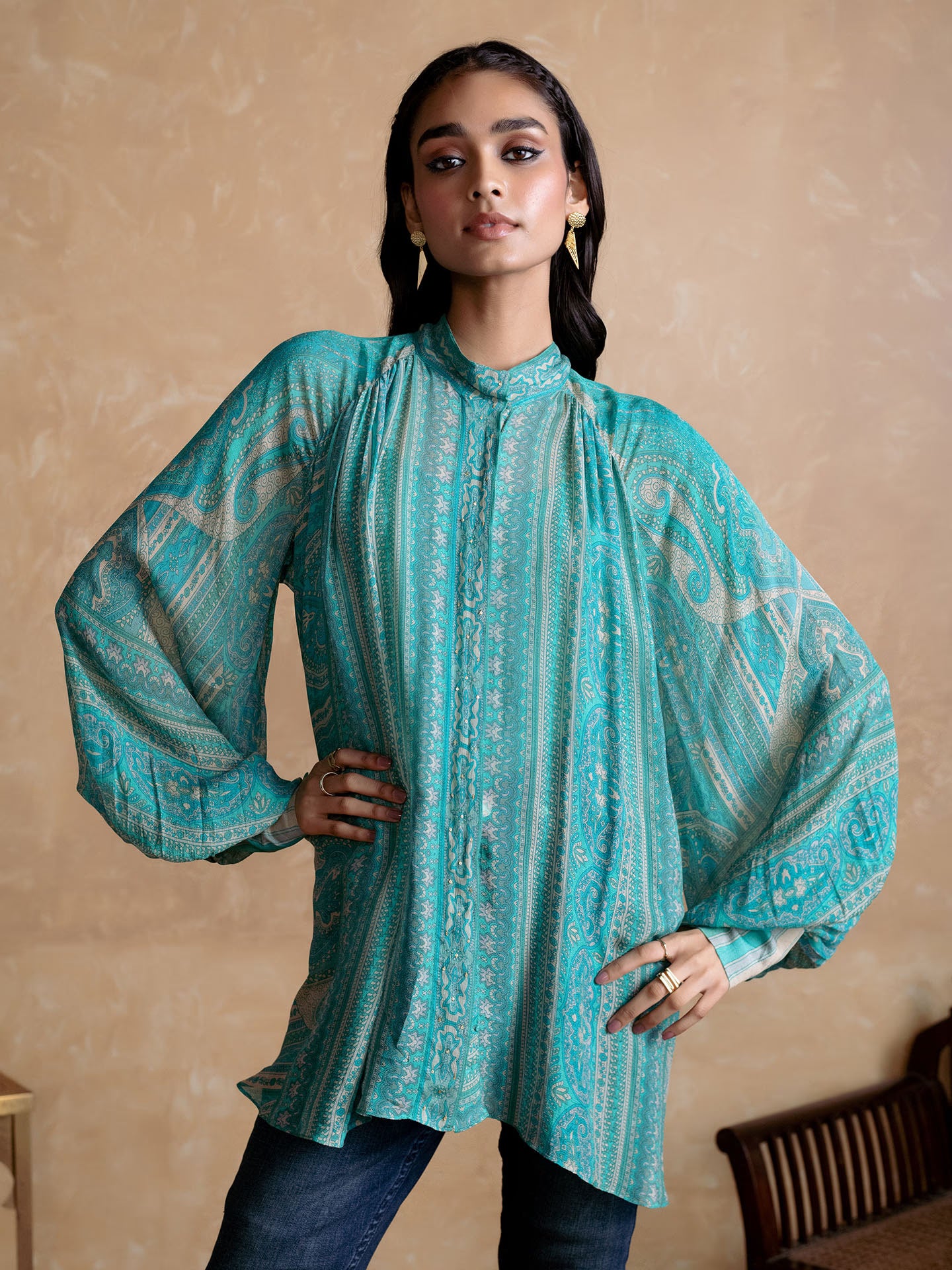 Woman wearing a Blue patterned Kurta against a beige background