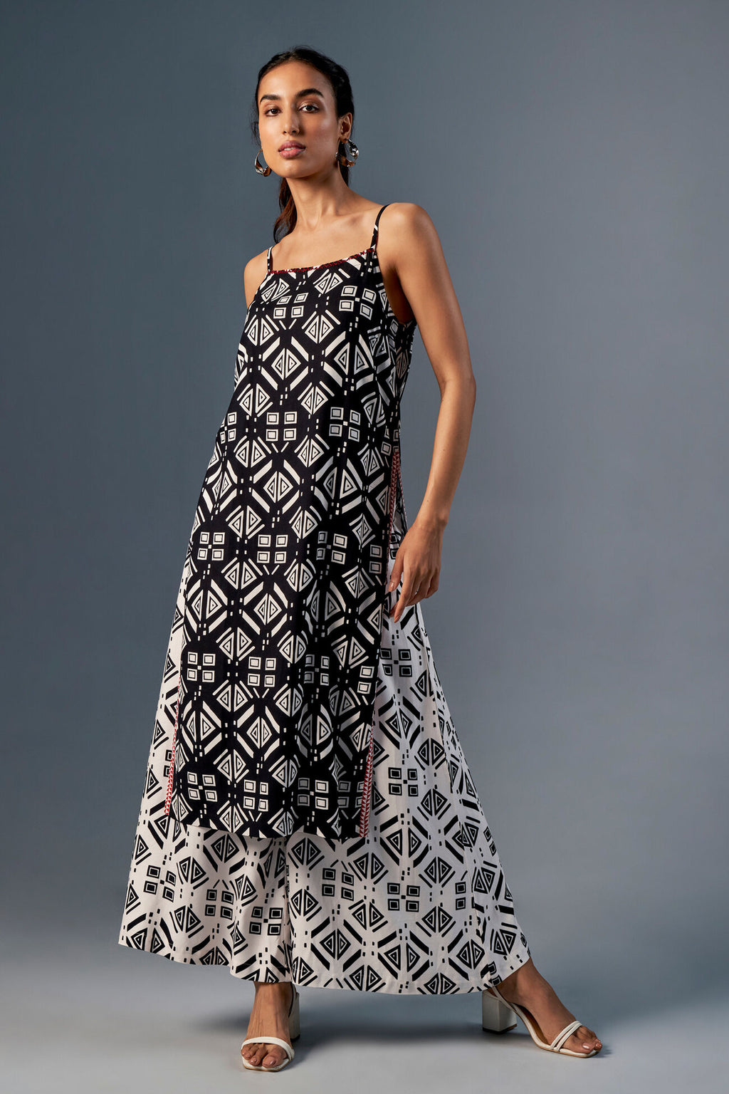 Woman wearing a black and white patterned dress on a gray background