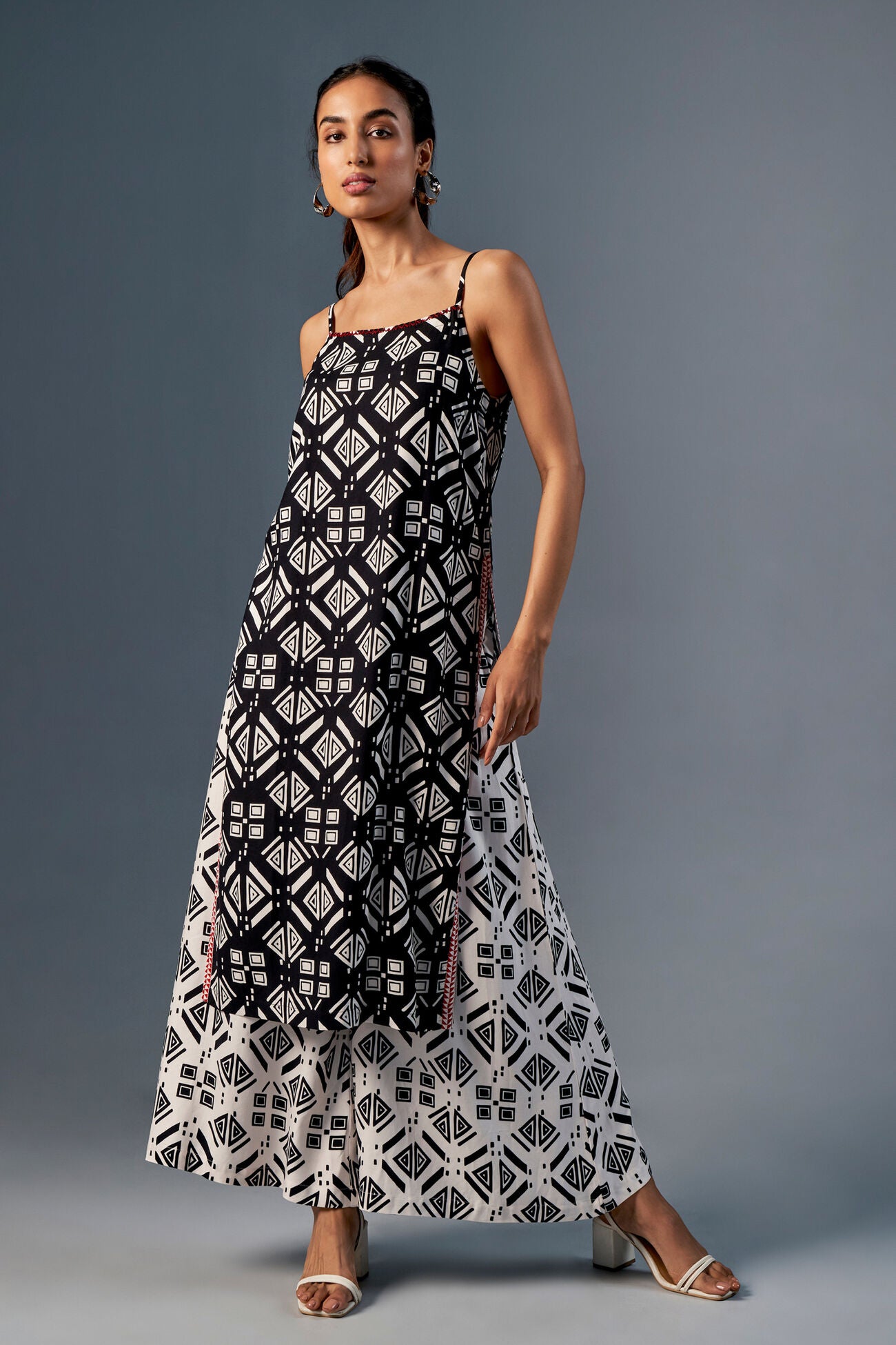 Woman wearing a black and white patterned dress on a gray background