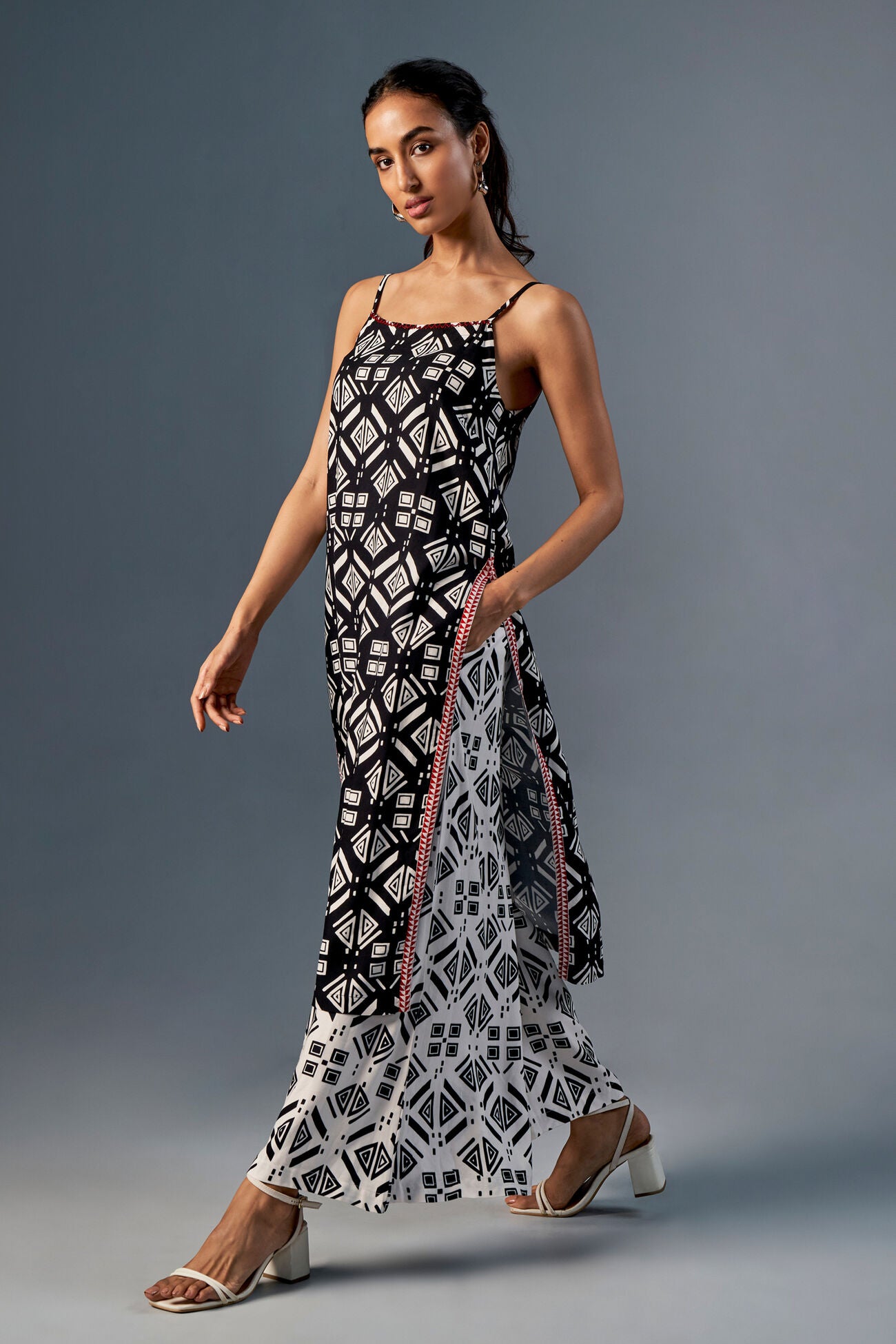 Woman wearing a black and white patterned dress on a gray background