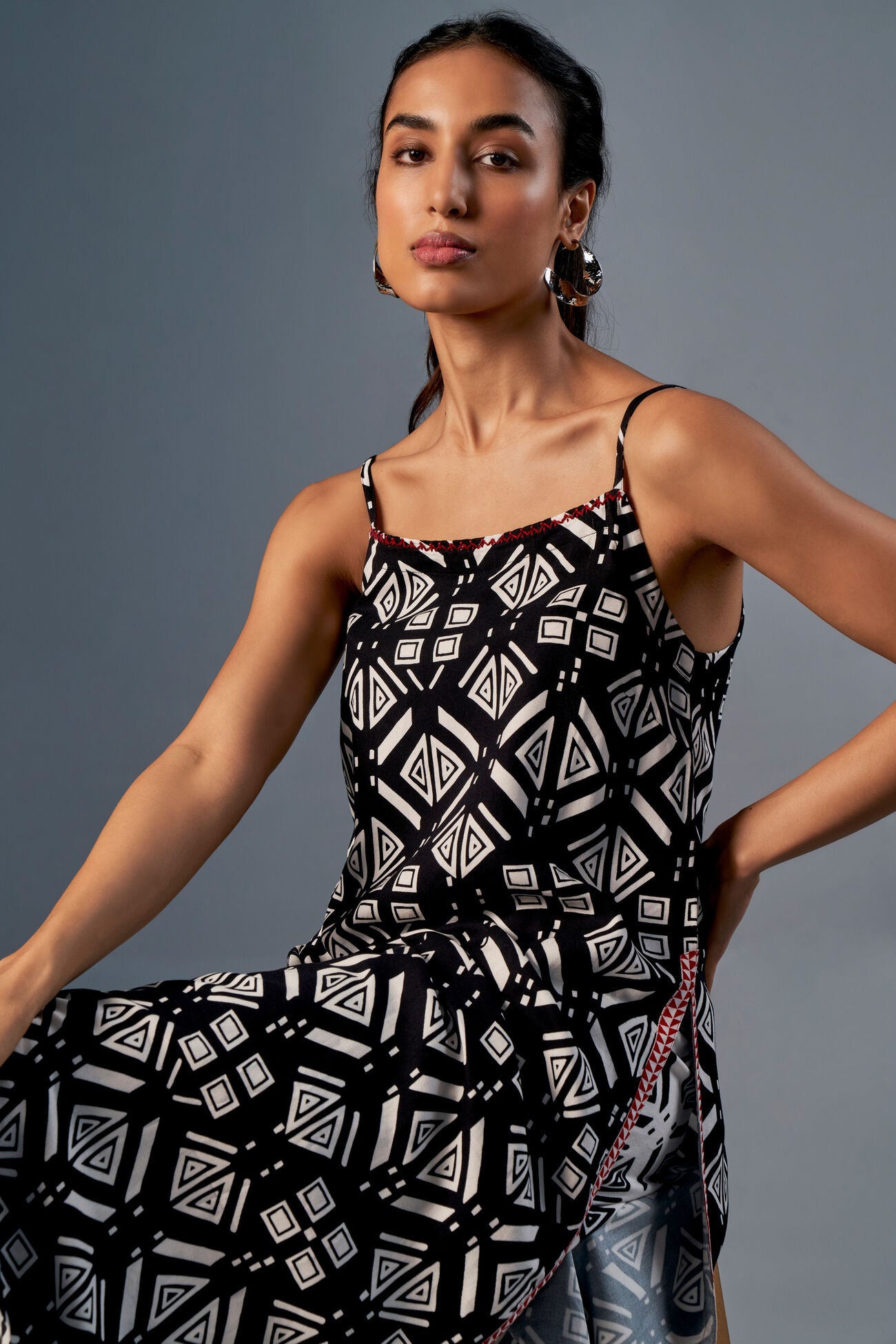 Woman wearing a black and white patterned dress against a gray background