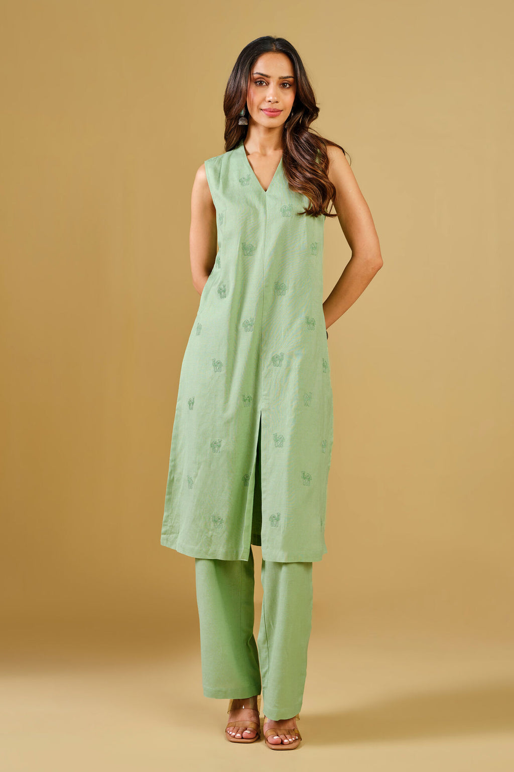 Woman wearing a green outfit against a beige background