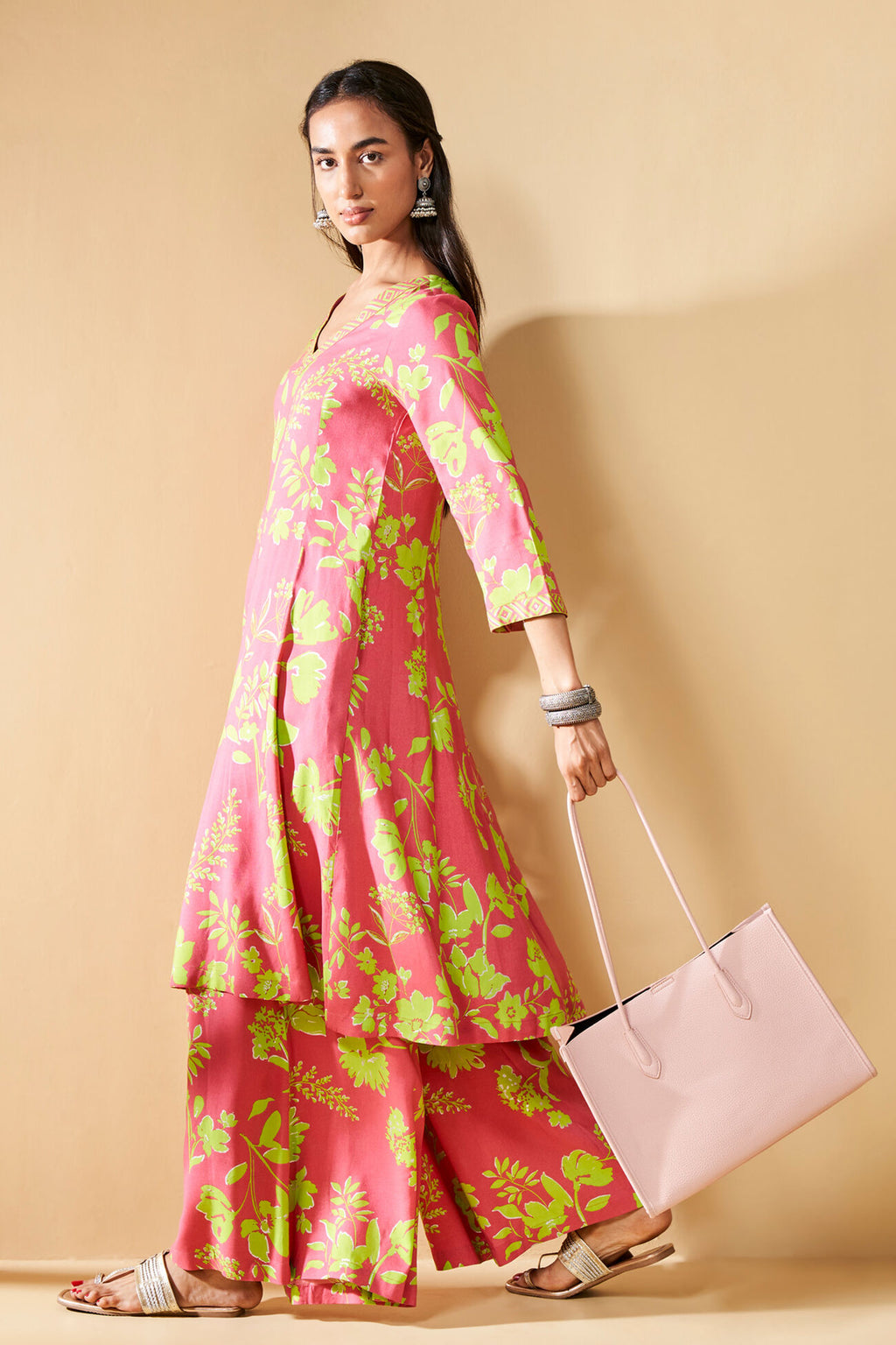 Pink dress with green floral pattern on a beige background