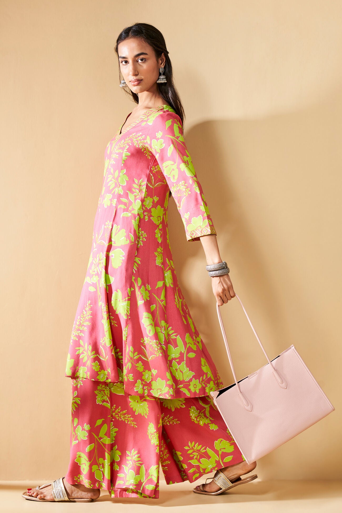 Pink dress with green floral pattern on a beige background