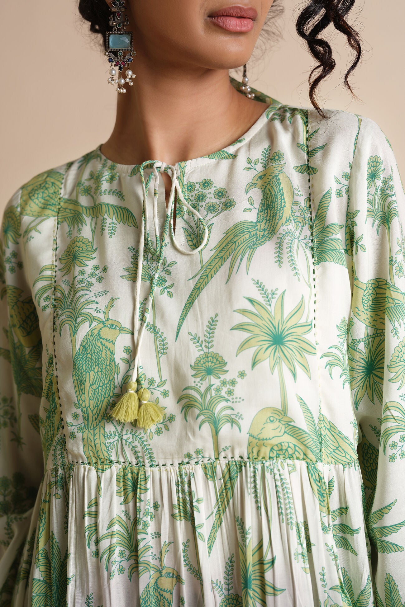 Woman wearing a green and white patterned dress with a neutral background