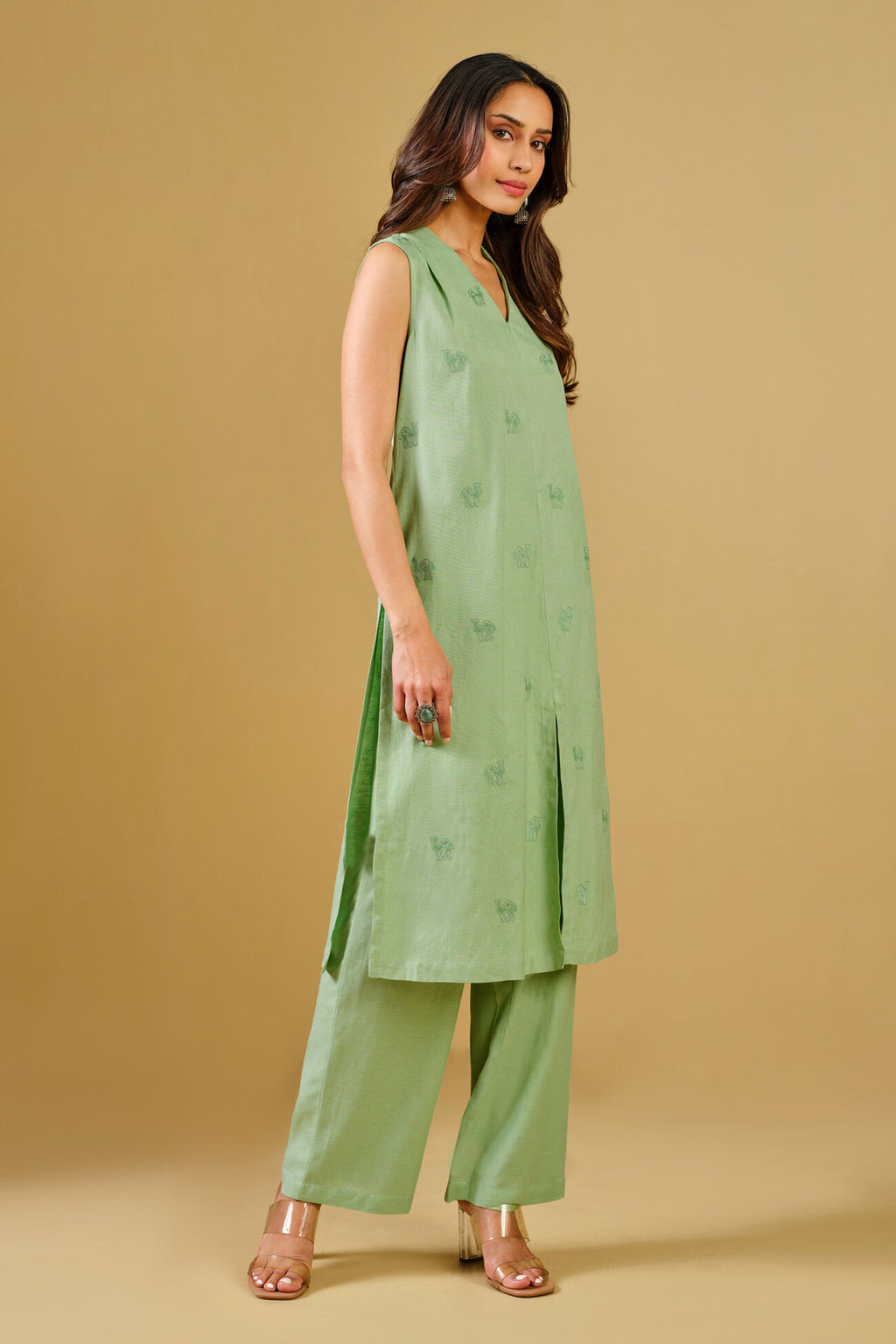 Woman wearing a green outfit with a plain background