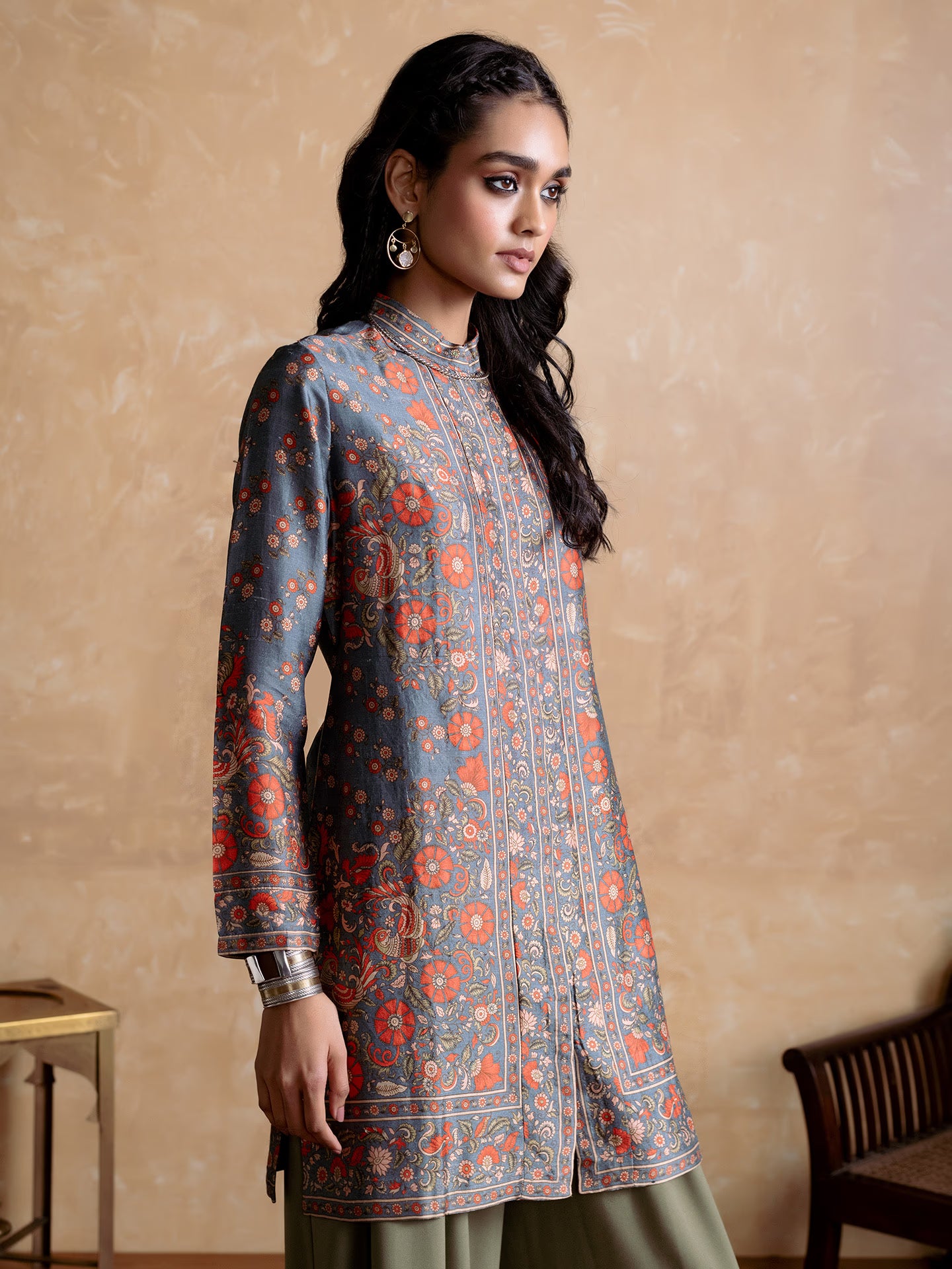 Woman wearing a floral patterned kurta against a beige background