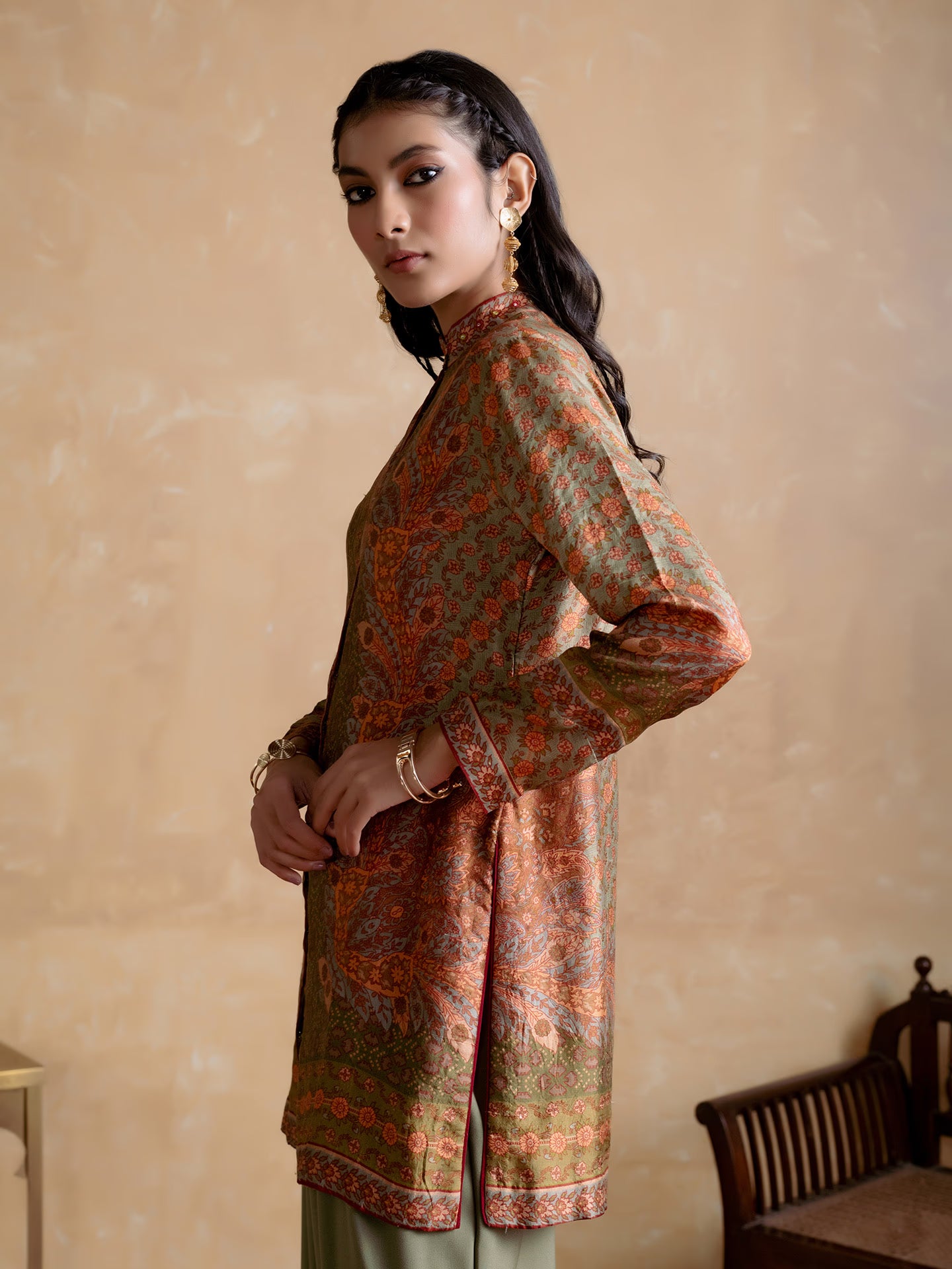 Woman wearing a patterned kurta with a beige wall background