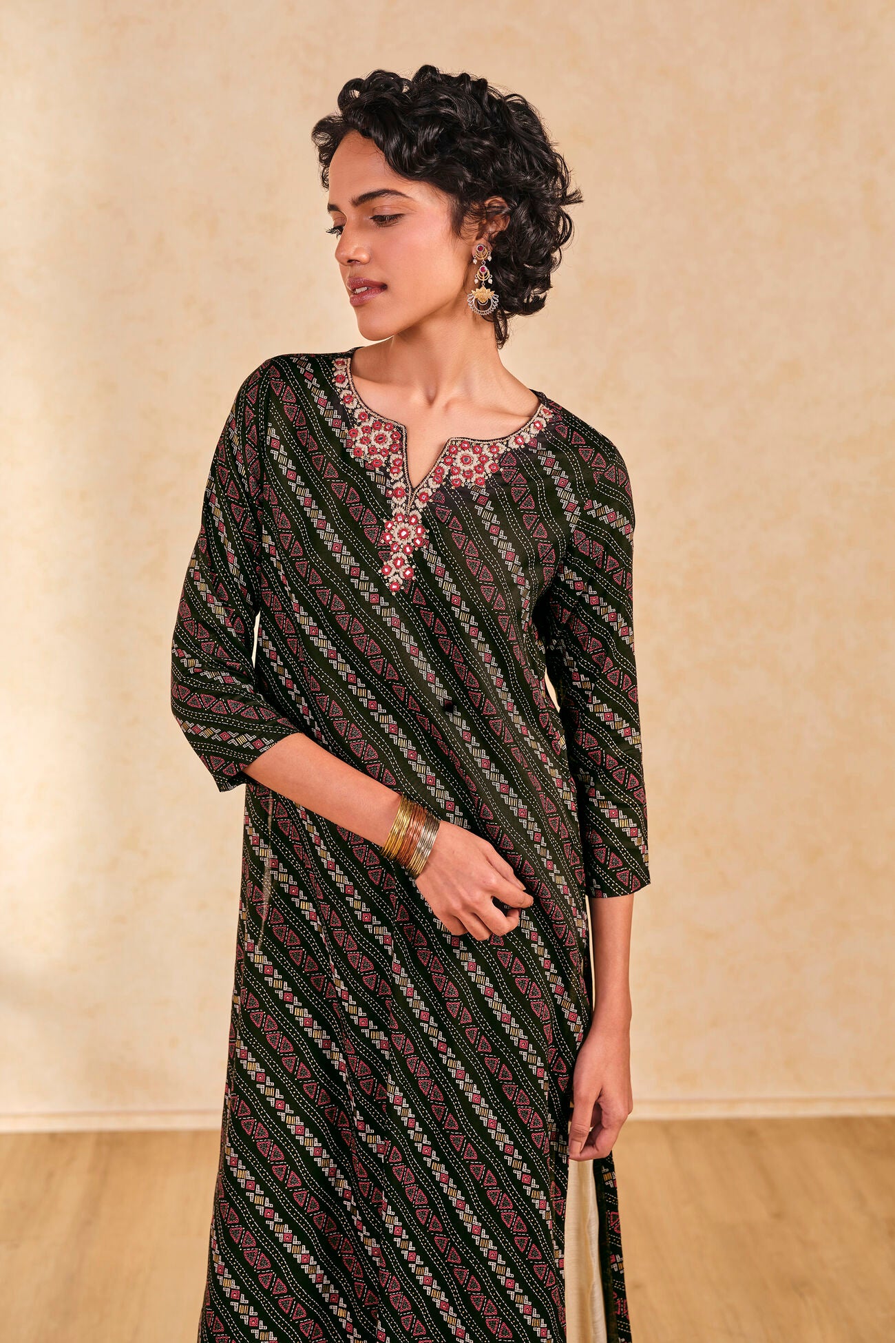 Woman wearing a patterned dress against a beige background