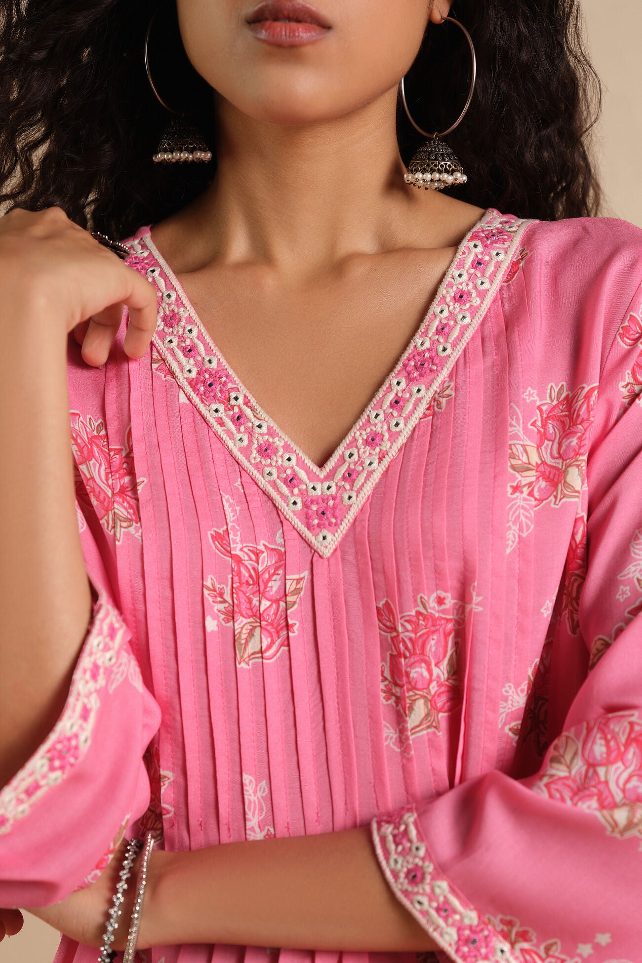 Close-up of a person wearing a pink traditional outfit with floral patterns.
