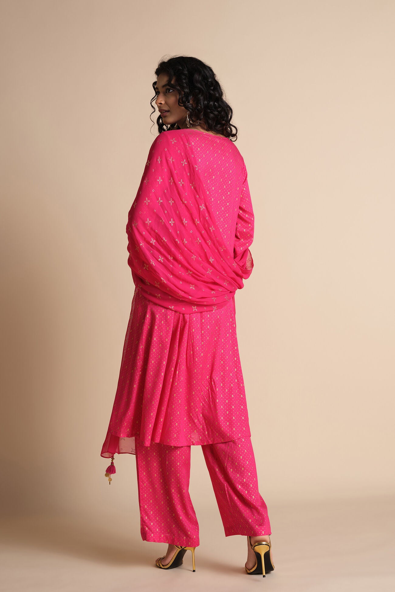 Woman wearing a pink traditional outfit with a beige background