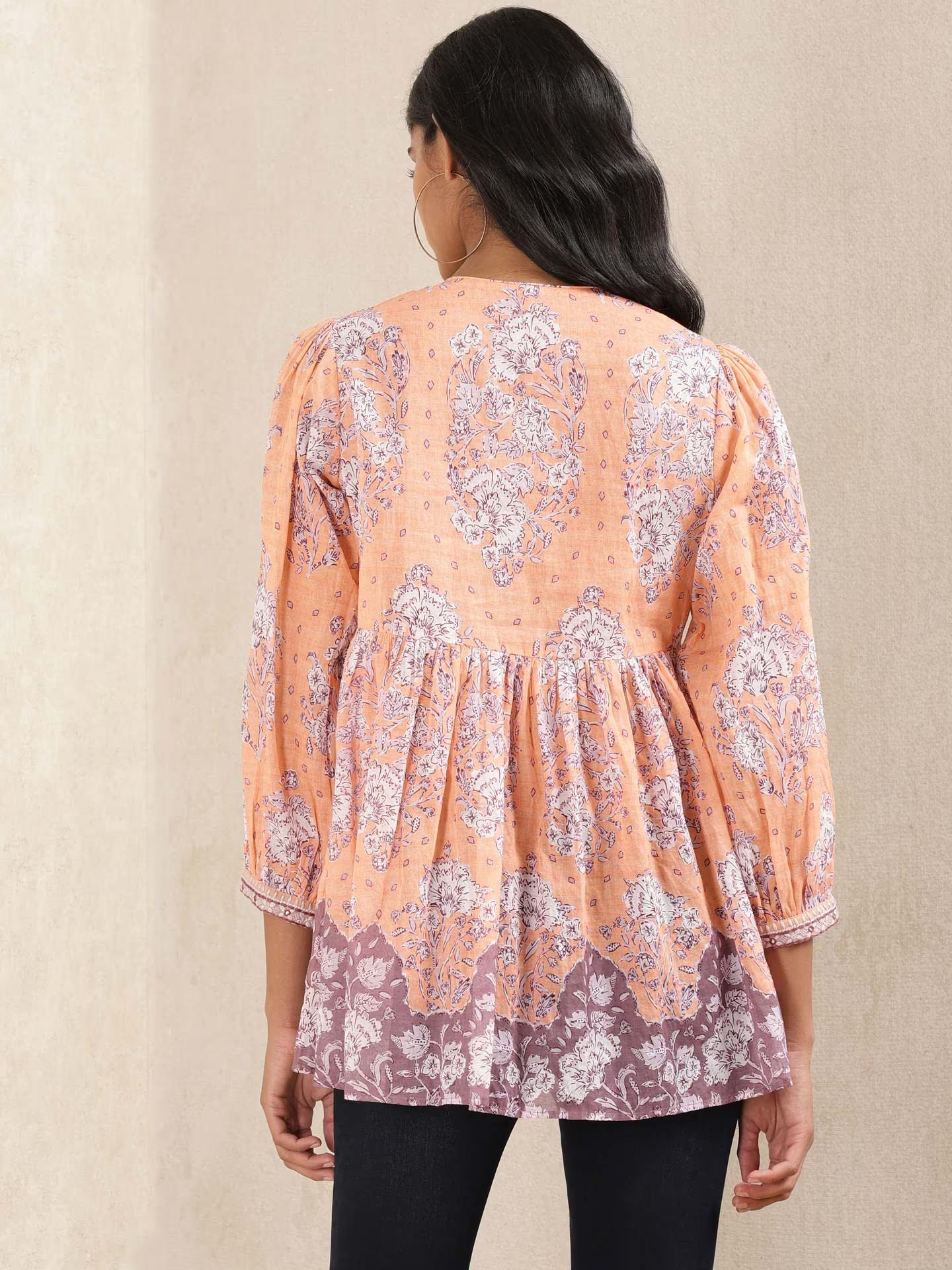 Woman wearing a floral blouse with a beige background