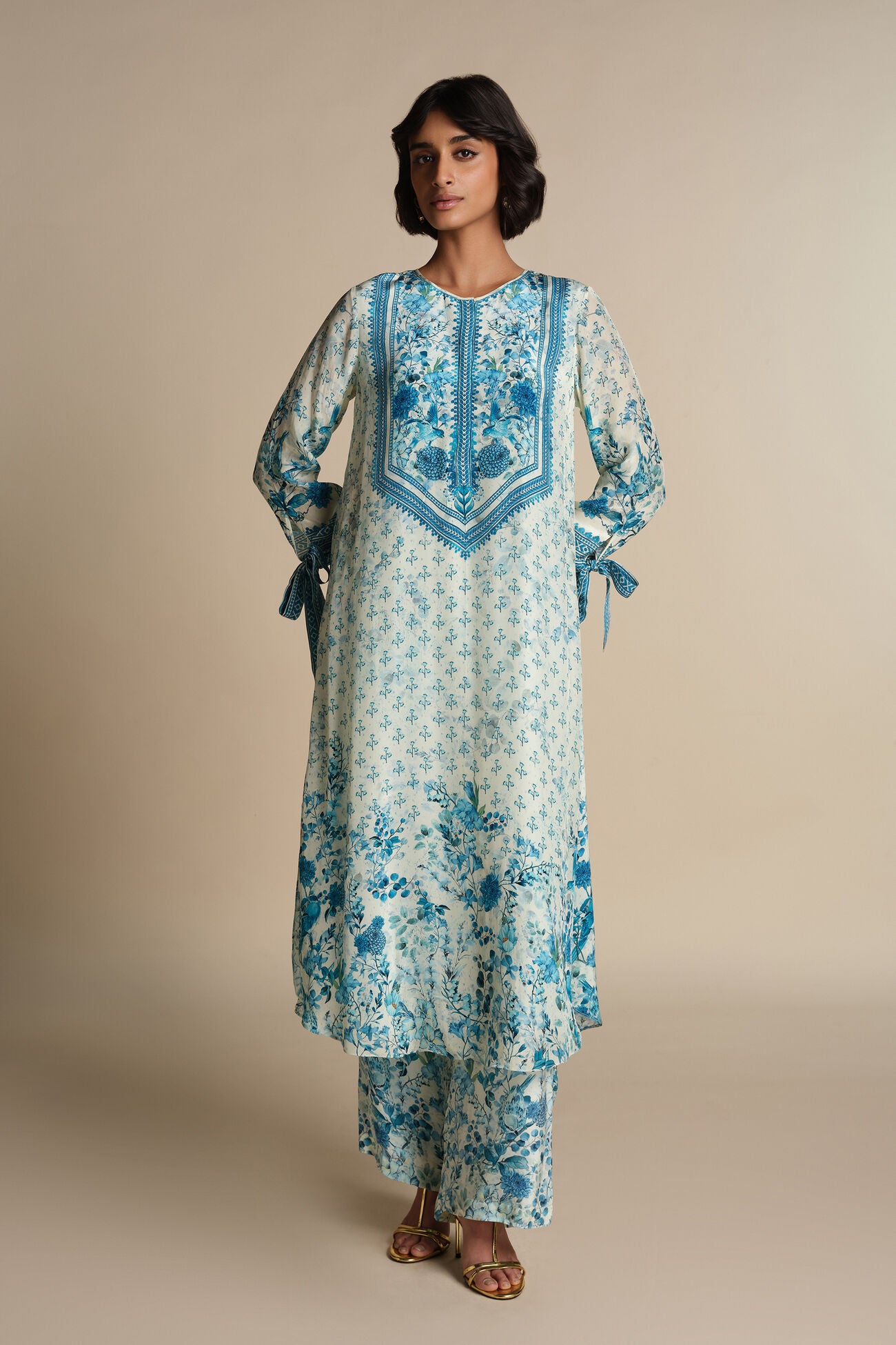 Woman wearing a floral embroidered outfit on a beige background