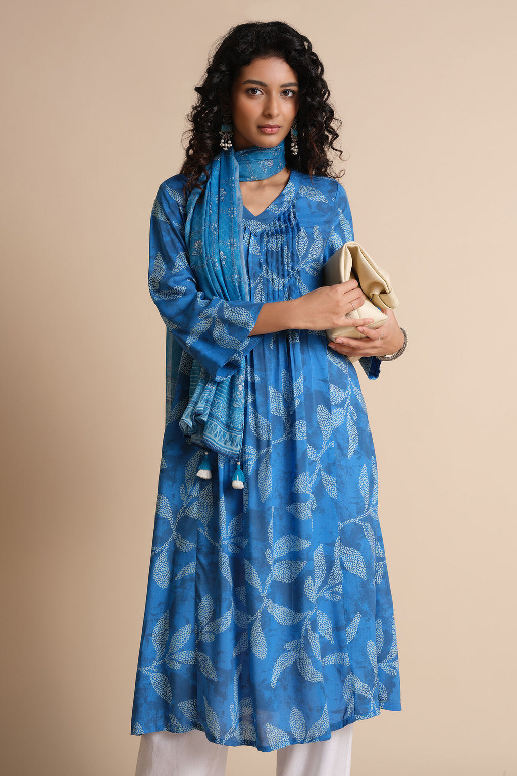 Woman wearing a blue patterned kurta with a beige background