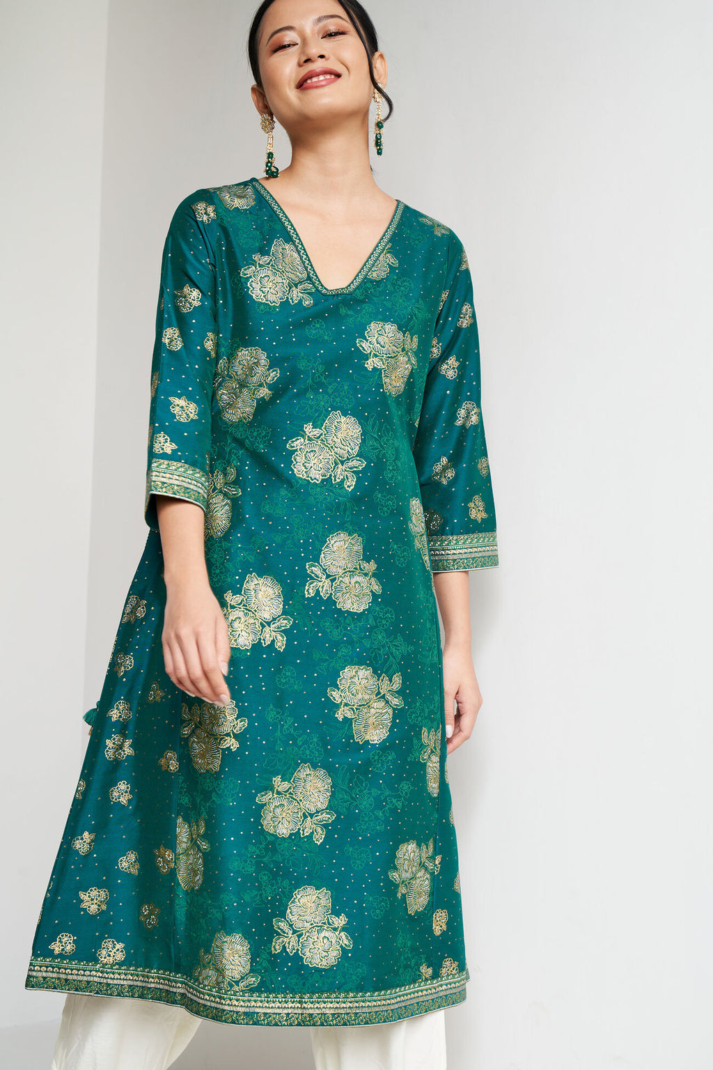 Woman wearing a green floral patterned dress against a white background