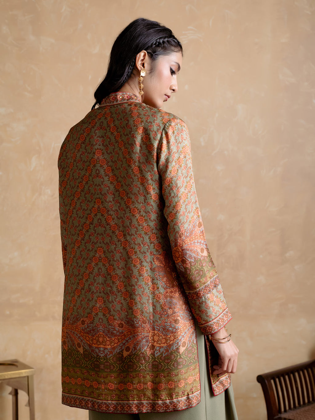 Woman wearing a patterned kurta against a beige background