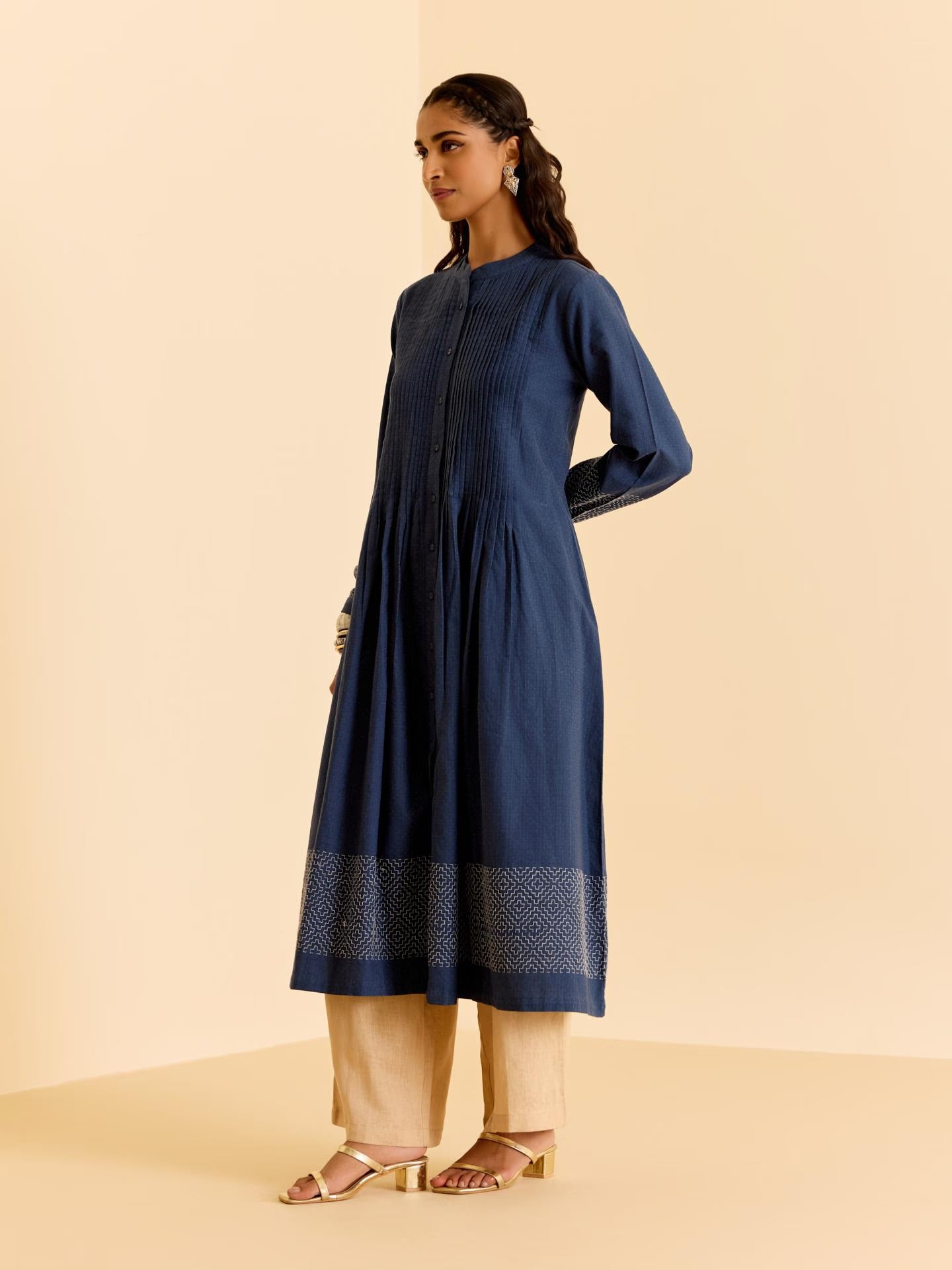 Woman wearing a blue kurta with beige pants on a beige background