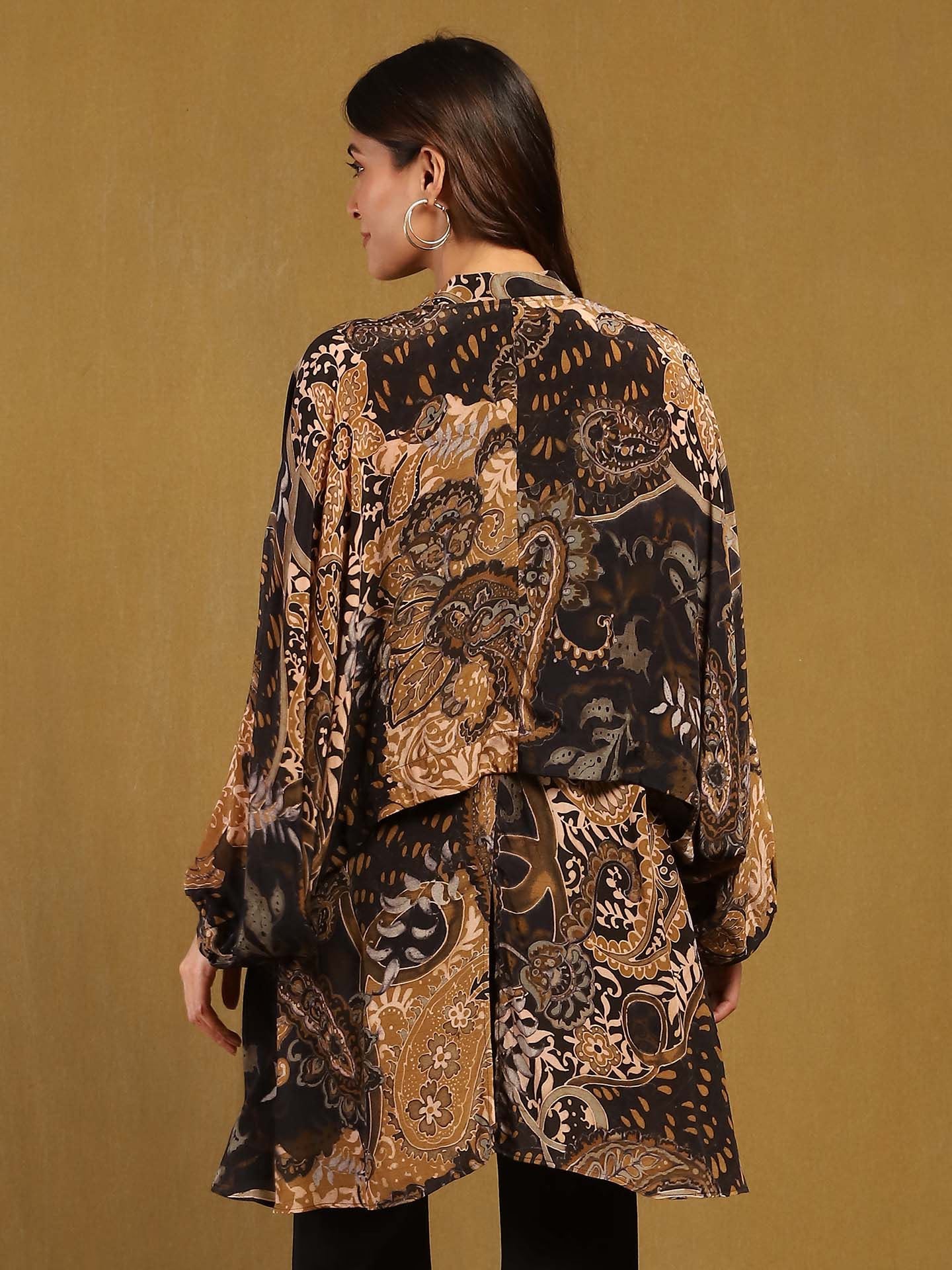 Woman wearing a patterned outfit against a beige background