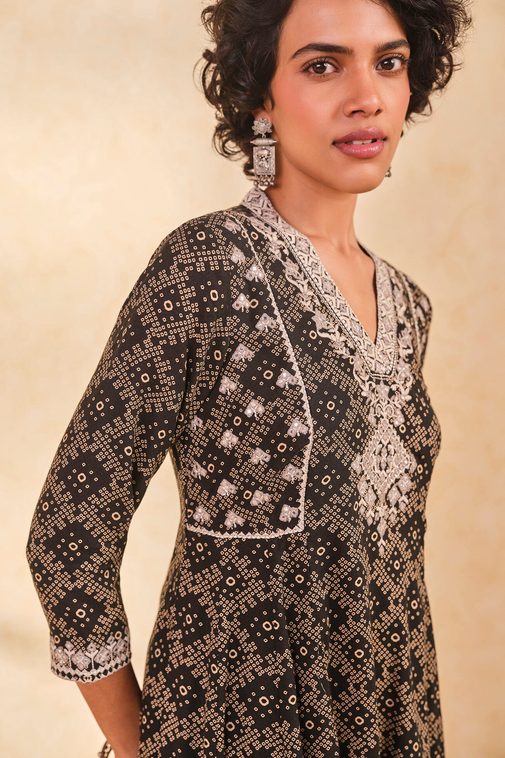 Woman wearing a patterned outfit with a beige background