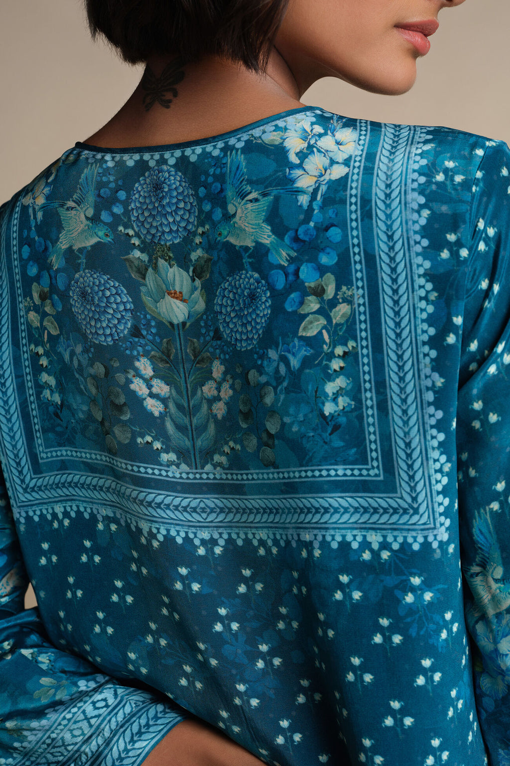 Teal embroidered garment with floral patterns
