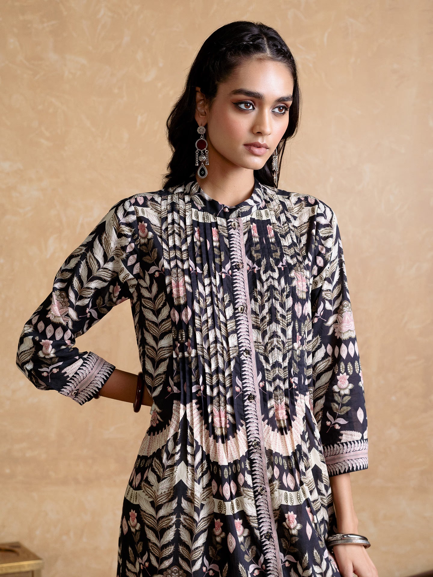 Woman wearing a patterned dress against a beige background