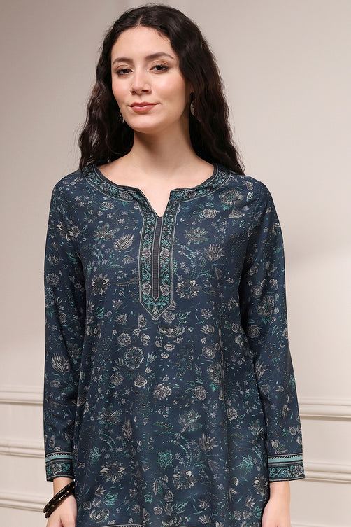 Woman wearing a dark blue floral patterned kurta against a neutral background