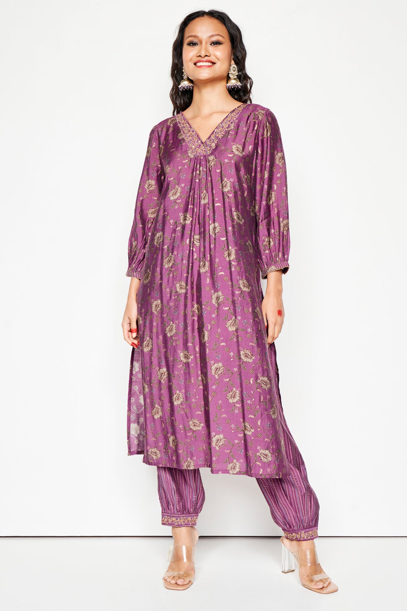 Woman wearing a purple traditional outfit with a white background