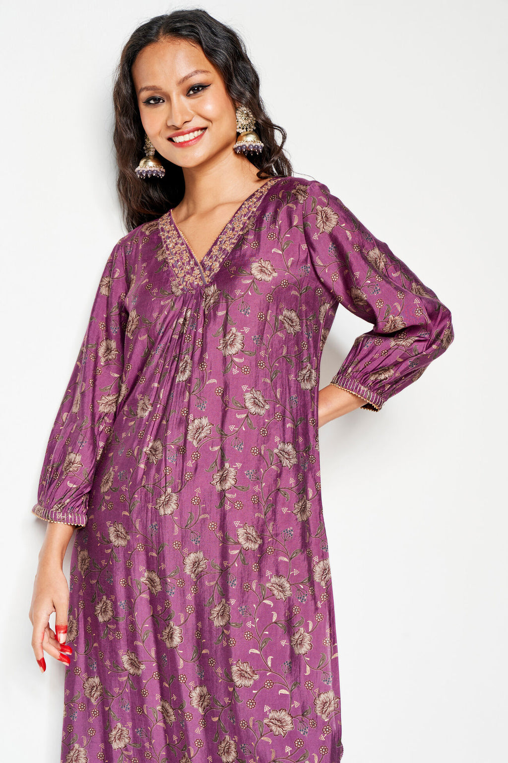 Woman wearing a purple floral dress against a white background