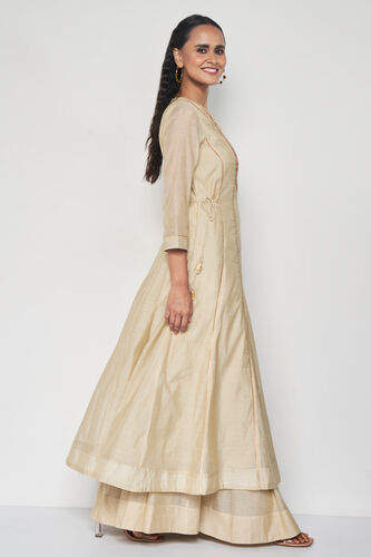 Woman wearing a beige dress with a plain white background