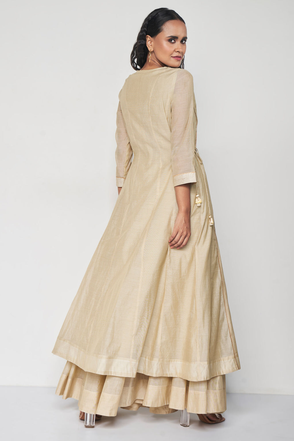 Woman wearing a beige traditional outfit on a white background