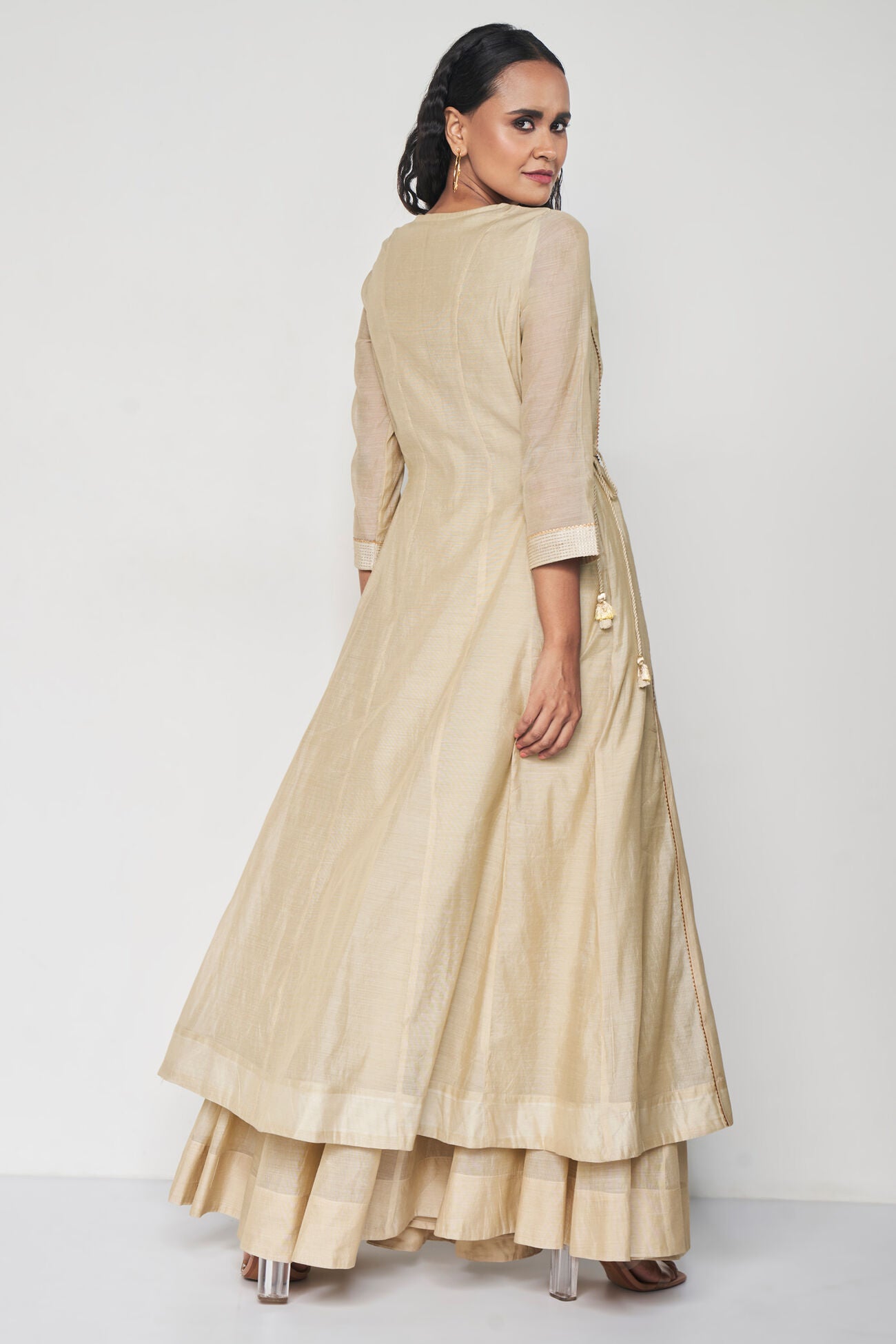 Woman wearing a beige traditional outfit on a white background