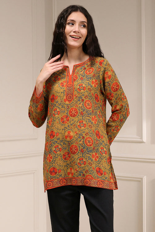 Woman wearing a patterned long-sleeve top against a neutral background