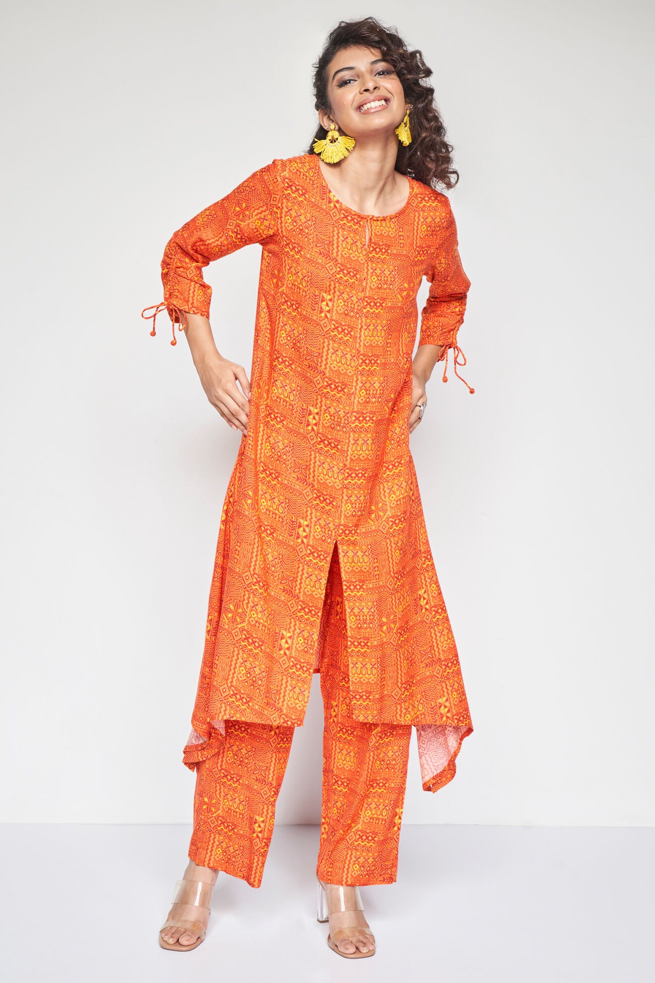 Woman wearing an orange traditional outfit with a white background