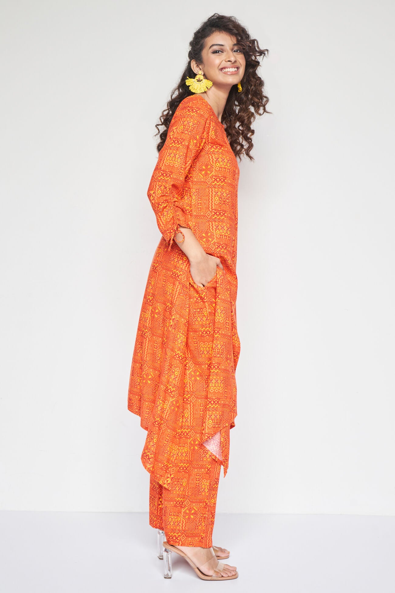 Woman wearing an orange traditional outfit with a white background