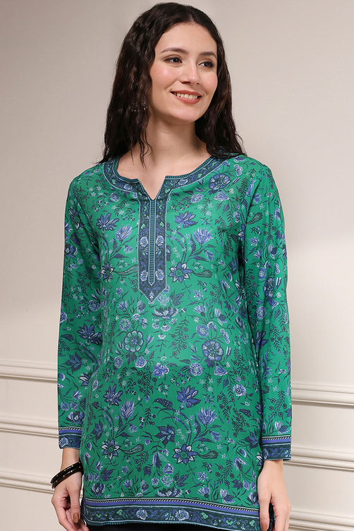 Woman wearing a green floral patterned kurta against a neutral background