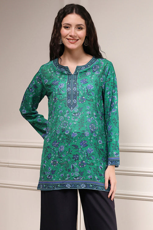 Woman wearing a green floral patterned top against a neutral background