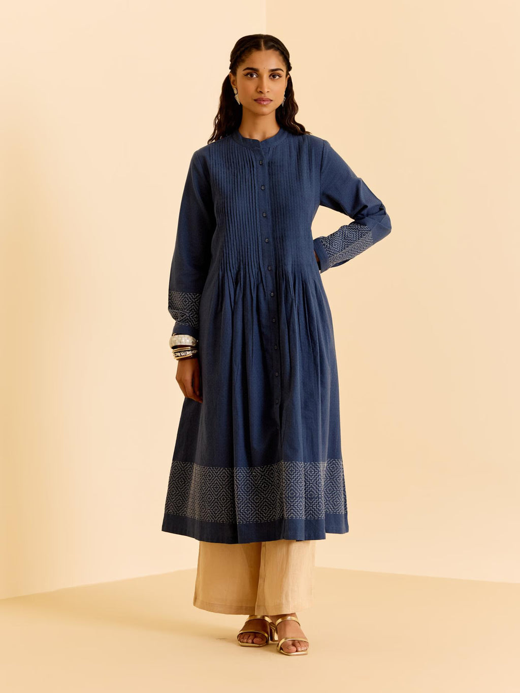 Woman wearing a blue kurta with beige pants on a beige background