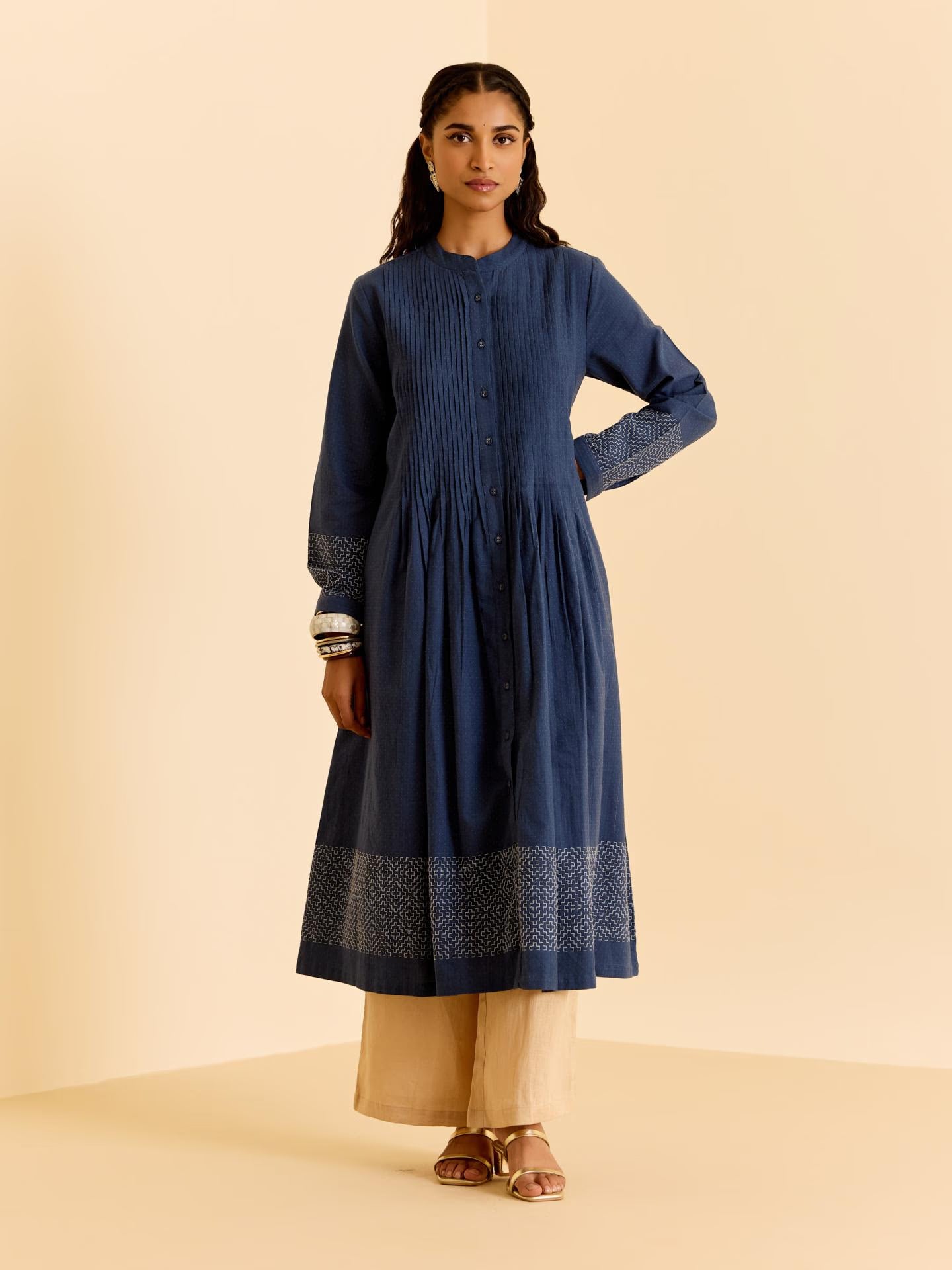 Woman wearing a blue kurta with beige pants on a beige background